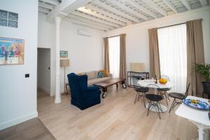 a living room with a couch and a table and chairs at Casa Miguel - Apartamento 3 in Sanlúcar de Barrameda