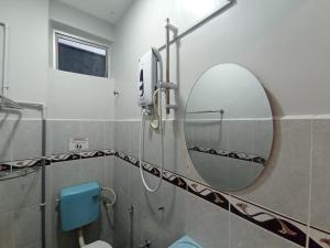 a bathroom with a round mirror and a toilet at D LAYARAN KUANTAN LPT Exit 833 in Kuantan