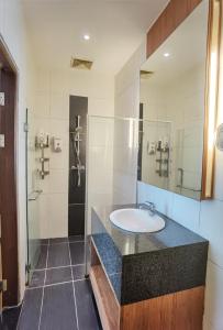 a bathroom with a sink and a shower at Jeff and Ricky Homestay16-Boulevard Imperial Suite in Kuching