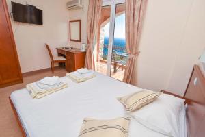 a bedroom with a bed with a view of the ocean at Apartments Villa Sveti Nikola in Budva