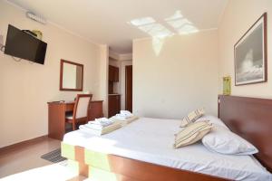 a bedroom with a bed and a desk and a television at Apartments Villa Sveti Nikola in Budva