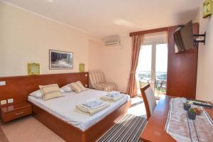a bedroom with a bed and a table and a window at Apartments Villa Sveti Nikola in Budva