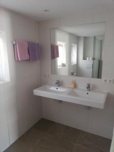 Un baño blanco con lavabo y espejo. en Haus Jirka, en Nauders