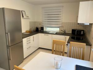 eine Küche mit einem Kühlschrank und einem Tisch mit Stühlen in der Unterkunft Ferienwohnung Vörstetten in Vörstetten