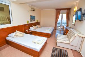 a hotel room with two beds and a tv at Apartments Villa Sveti Nikola in Budva