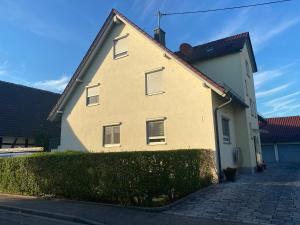 Ferienwohnung Vörstetten في Vörstetten: منزل اصفر بسقف احمر