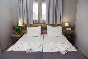 a bedroom with two beds with towels on them at Hotel Coral in Skala Rachoniou