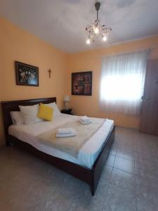 a bedroom with a large bed with a chandelier at Gianna's House in Paradisos