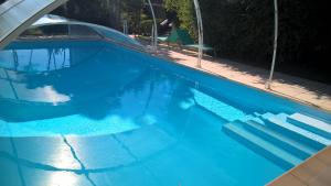 een zwembad met blauw water en een trap bij LESSENCIEL in Tournay