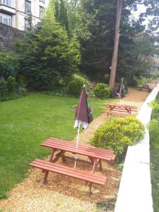 two picnic tables with an umbrella in a park at The Hand Hotel in Llangollen