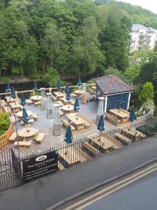 a group of tables and chairs with blue umbrellas at The Hand Hotel in Llangollen