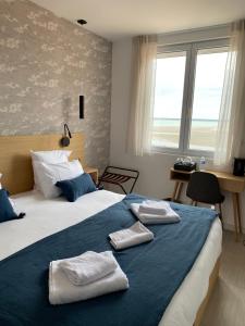 a bedroom with a large bed with towels on it at Hôtel L'Albatros in Saint-Trojan-les-Bains