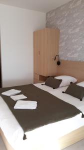 a bedroom with a large bed with towels on it at Hôtel L'Albatros in Saint-Trojan-les-Bains