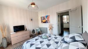 ein Schlafzimmer mit einem Bett und einem TV in der Unterkunft Appartement F2 refait à neuf tout confort in Montluçon