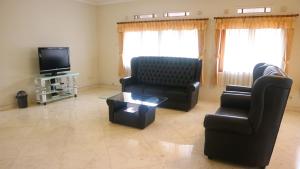 ein Wohnzimmer mit 2 Stühlen und einem TV in der Unterkunft Dago Asri House (3 Bedrooms, 6 Pax, 500m2) in Bandung