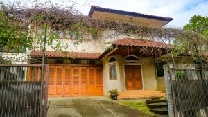 ein Haus mit einer orangenen Tür und einem Tor in der Unterkunft Dago Asri House (3 Bedrooms, 6 Pax, 500m2) in Bandung