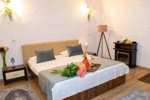 a bedroom with two beds and a table with flowers on it at Le Premier in Constanţa