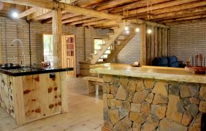 uma grande cozinha com um balcão de pedra num quarto em Chalé Refúgio Panorâmico em Canela