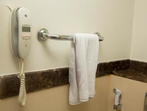 a white towel hanging on a wall next to a shower at Marco Polo Hotel in Dubai