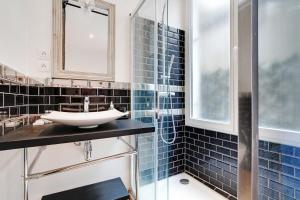 a bathroom with a sink and a shower with blue tiles at CMG - Cosy Studio 4P Tiquetonne Chatelet in Paris