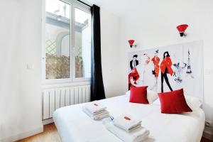 a bedroom with a white bed with red pillows at CMG - Cosy Studio 4P Tiquetonne Chatelet in Paris