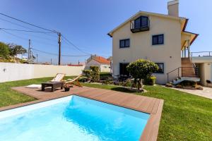 een achtertuin met een zwembad en een huis bij Viana Fishers House - Amazing Apartments in Front of the Sea in Viana do Castelo