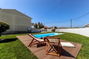 een paar stoelen op een terras naast een zwembad bij Viana Fishers House - Amazing Apartments in Front of the Sea in Viana do Castelo