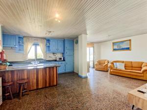 a large kitchen with blue cabinets and a couch at Viana Fishers House - Pool & Beach ! in Viana do Castelo