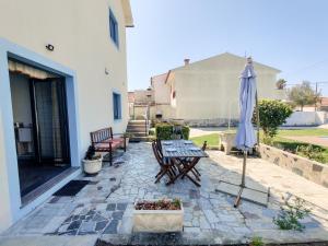 a patio with a table and an umbrella at Viana Fishers House - Pool & Beach ! in Viana do Castelo