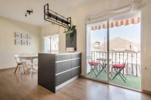 una cucina con tavolo e sedie e un balcone di Luz de Sevilla Free parking a Siviglia