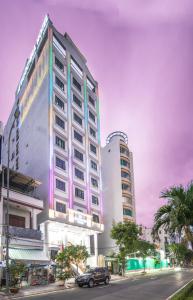 un edificio con un'auto parcheggiata di fronte a una strada di Le Indochina Hotel & Beach Da Nang City a Da Nang