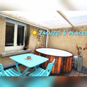 a table and chairs on a patio with a table and a barrel at L'Antique SPA: jacuzzi sous patio in Orange