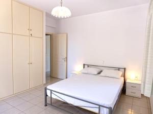 a white bedroom with a large bed and a chandelier at Villa Serena in Mitikas