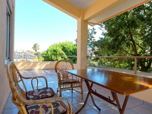 a porch with a wooden table and chairs on a balcony at Villa Serena in Mitikas