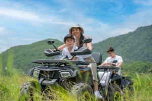 a woman and a child riding on a four wheeler at Te Mata Glamping in Nong Nam Daeng