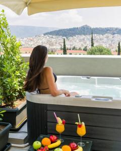 a woman sitting in a bath tub with a view at Athens Panorama Project in Athens