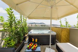 a hot tub on a balcony with an umbrella at Athens Panorama Project in Athens