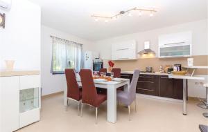 a kitchen and dining room with a table and chairs at Cozy Apartment In Smrika With Kitchen in Šmrika