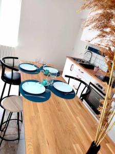 - une table en bois avec des chaises, des assiettes et des verres à vin dans l'établissement L'Antique SPA: jacuzzi sous patio, à Orange