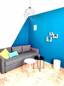 a living room with a couch and a blue wall at L'Antique SPA: jacuzzi sous patio in Orange