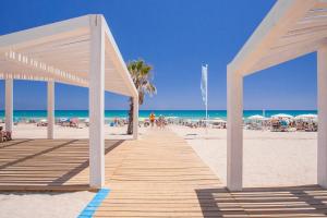 - une promenade en bois sur la plage avec des personnes sur le sable dans l'établissement Apartamento Sweet Atico Torre del Mar Alicante - San Juan Playa, à Alicante