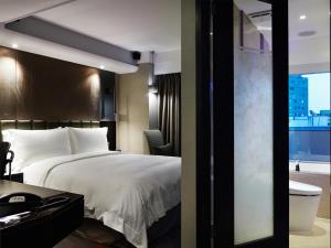 Rúm í herbergi á The Tango Hotel Taipei FuHsing