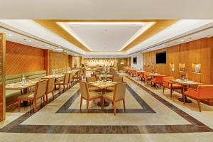 a restaurant with wooden walls and tables and chairs at Golden Tulip Jalandhar in Jalandhar
