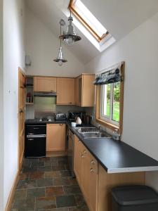 a kitchen with wooden cabinets and a black counter top at The Cottage, near Glasgow Milngavie in Milngavie