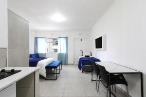 a hotel room with a bed and a table and chairs at Sea Point apartment in Cape Town