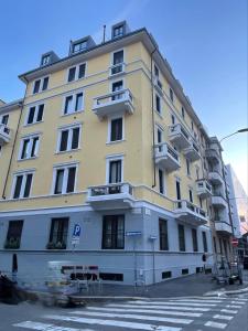 ein großes gelbes Gebäude mit Balkonen auf einer Straße in der Unterkunft Blue Design Suite in Mailand