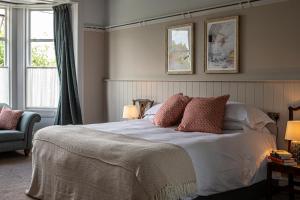 um quarto com uma cama com almofadas e 2 janelas em Burrator Inn em Yelverton