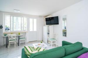 - un salon avec un canapé vert et une table dans l'établissement Apartment Laneta, à Dubrovnik