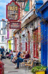 un gruppo di persone seduti fuori da un edificio di Foley's Guesthouse & Self Catering Holiday Homes a Kenmare