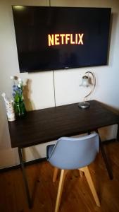 a desk with a chair and a television on a wall at Teas & Seas Self Catering Cottage in Cape Town